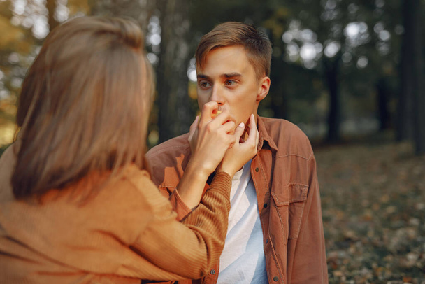 Couple in a park. Guy in a brown shirt. Golden autumn. - Valokuva, kuva