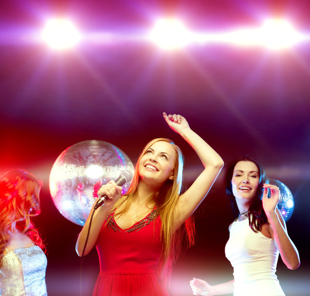 three smiling women dancing and singing karaoke - Fotoğraf, Görsel