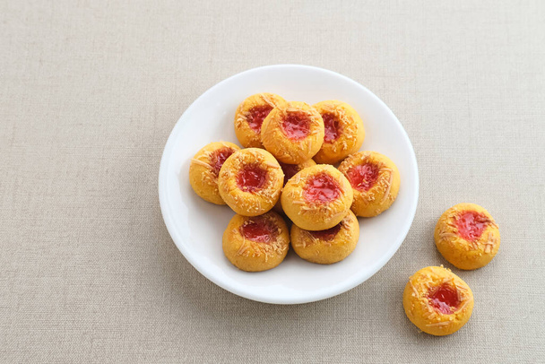 Μπισκότα εκτύπωσης αντίχειρα γεμάτα μαρμελάδα φράουλα και τριμμένο τυρί. Γνωστή κατά τη διάρκεια του μήνα Ramadan και Eid Fitri. - Φωτογραφία, εικόνα