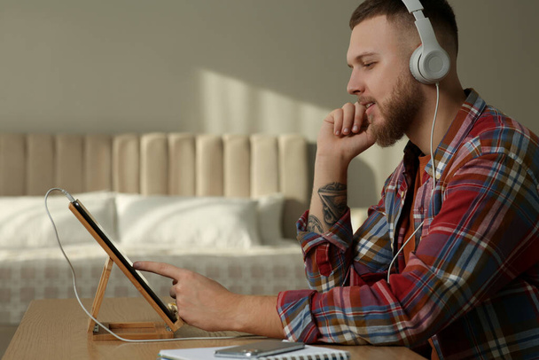 Online test. Man studying with tablet at home - Fotó, kép