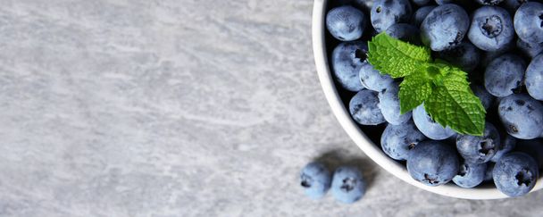 Tasty fresh blueberries on grey table, top view with space for text. Banner design - Photo, image