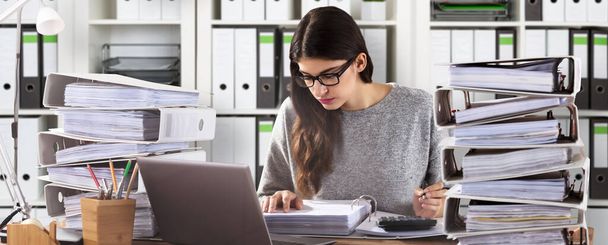 Jeune femme d'affaires portant des lunettes Calcul de facture au bureau
 - Photo, image