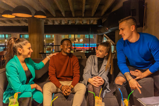 Group of multiracial friends are smiling and talking to each other - Foto, afbeelding
