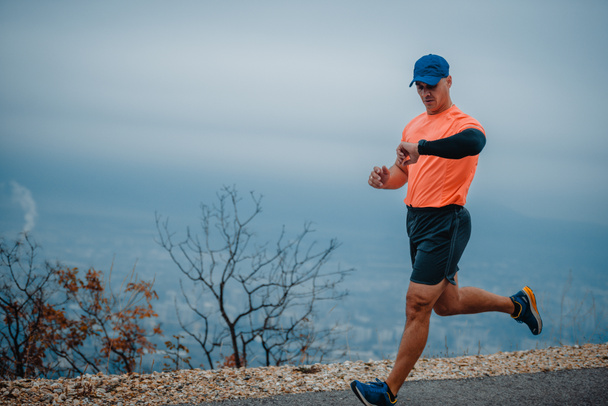 Fit man powyżej 40 roku życia noszący strój aktywny podczas ćwiczeń biegowych - Zdjęcie, obraz