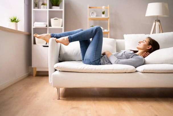 Low Section View Of A Woman Relaxing On Sofa - Photo, Image