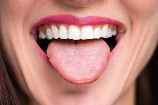 Primer plano de la cara de una mujer mostrando su lengua limpia
 - Foto, imagen