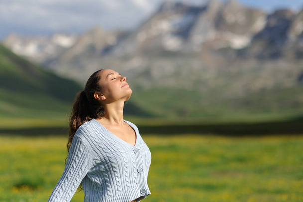 Casual woman breathing fresh air in a green mountain a sunny day - Фото, зображення