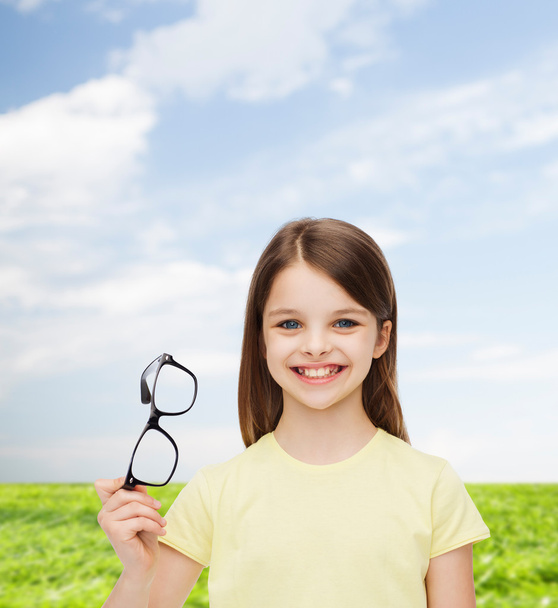 smiling cute little girl holding black eyeglasses - Foto, immagini