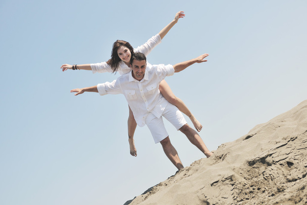 Ευτυχισμένο νεαρό ζευγάρι διασκεδάστε στην παραλία - Φωτογραφία, εικόνα
