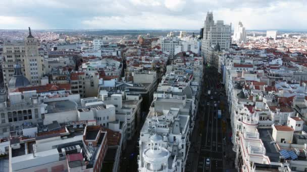Paisaje urbano aéreo de Madrid con tráfico de coches en la calle Gran Vía, España. Vista panorámica de la ciudad con alto edificio de oficinas y áreas de vivienda densamente construidas - Imágenes, Vídeo