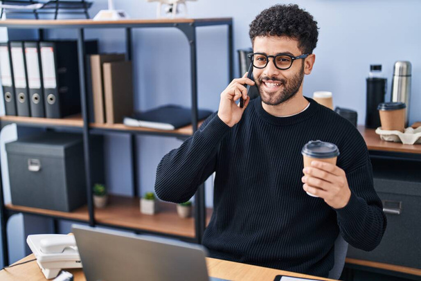 młody arabski człowiek biznes pracownik mówi na smartfonie pracuje w biurze - Zdjęcie, obraz