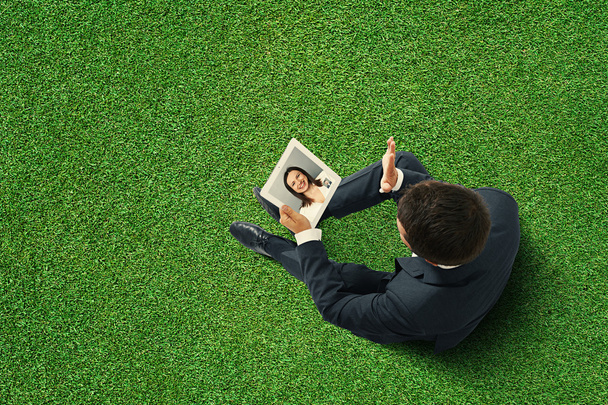 Mann sitzt auf der grünen Rasenfläche - Foto, Bild