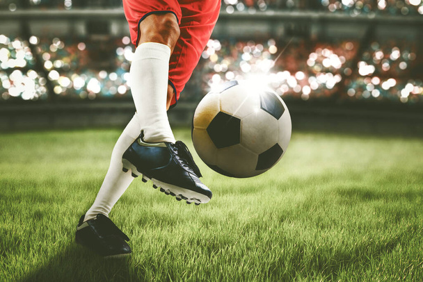 Close up of soccer player feet shooting a ball with powerful toward a goal while playing on a stadium with crowds spectators background - Photo, Image