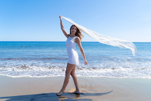 Lány a strandon, gyönyörű nő fehér sállal a nyári strandon, szabadság és pihenés, tűzmozgás - pénzügyi függetlenség nyugdíjba korai koncepció - Fotó, kép