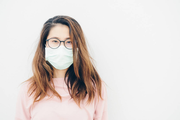Porträt einer kranken Asiatin, die eine Maske trägt, um sich vor Infektionskrankheiten durch Viren oder schlechter Umweltverschmutzung durch PM2,5-Smog zu schützen. Konzept der Gesundheitsfürsorge und des Gesundheitszustandes. - Foto, Bild