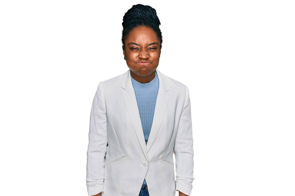 Jonge Afro-Amerikaanse vrouw die zakelijke kleren draagt en wangen puft met een grappig gezicht. mond opgeblazen met lucht, gekke uitdrukking.  - Foto, afbeelding