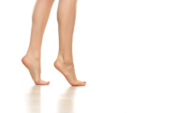 Side view of beautifully cared women's legs and feet on white background. - Photo, Image