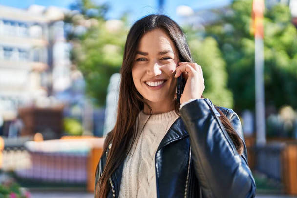 Jeune femme souriant confiant parler sur le smartphone au parc - Photo, image