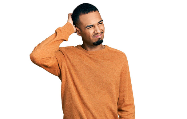 Jeune homme afro-américain portant des vêtements décontractés confondre et se poser des questions. incertain avec doute, pensant la main sur la tête. concept coûteux.  - Photo, image