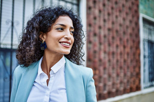 Young hispanic business woman wearing professional look smiling confident at the city - Fotoğraf, Görsel