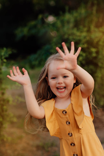 Portret małej dziewczynki na polu letnim pszenicy. Szczęśliwego dzieciństwa. Przygoda, podróże, turystyka, turystyka i koncepcja ludzi - szczęśliwy spacer rodzinny - Zdjęcie, obraz