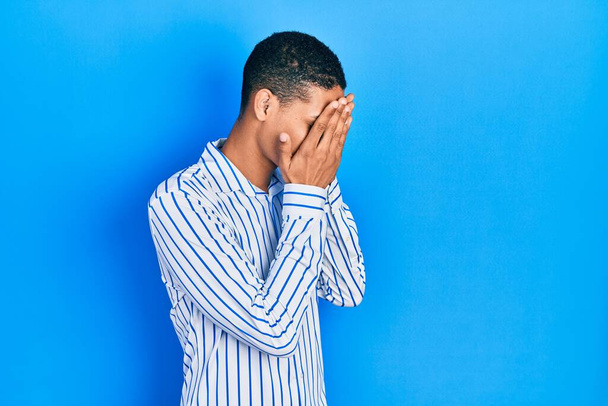 Young african american guy wearing casual clothes with sad expression covering face with hands while crying. depression concept.  - Fotografie, Obrázek