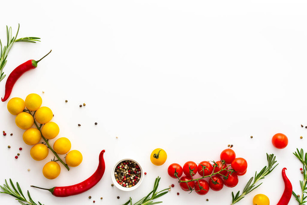 Gelbe und rote Tomaten, Paprika, Rosmarin und Gewürze auf weißem Hintergrund, Lebensmittelhintergrund, Draufsicht, Kopierraum - Foto, Bild