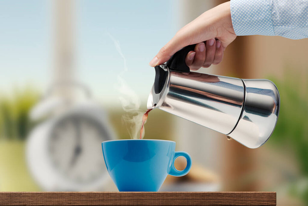 Woman having a coffee break, she is pouring hot coffee in a cup - Fotografie, Obrázek
