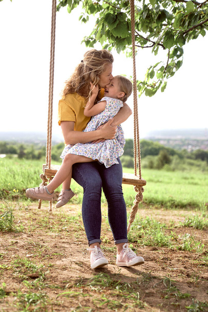 Mãe balançando com a filhinha no dia de verão - Foto, Imagem