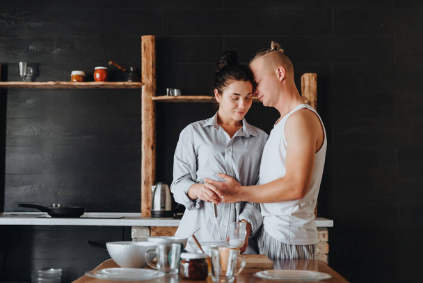 Νεαρό ερωτευμένο ζευγάρι μαγειρεύουν υγιεινά τρόφιμα στην κουζίνα μαζί.  - Φωτογραφία, εικόνα