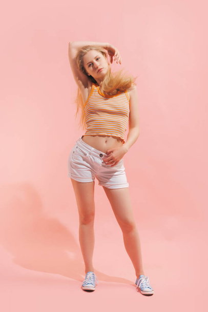 Dreaming. Studio shot of young pretty girl in summer fashion collection outfit posing isolated on pink background. Concept of emotions, facial expression, youth, aspiration, sales - Fotoğraf, Görsel