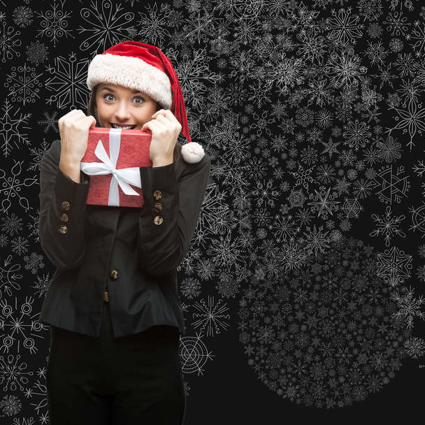 business woman in santa hat holding gift - Photo, image