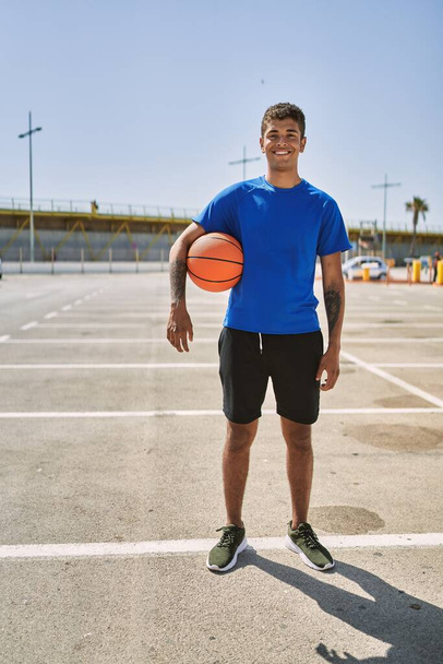 Genç İspanyol adam basketbol topuyla dışarıda antrenman yapıyor. - Fotoğraf, Görsel
