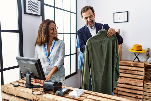 Мужчины и женщины среднего возраста, работающие в магазине одежды - Фото, изображение