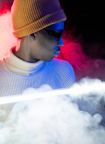 Creative portrait. Neon night. Stylish guy. Vaporwave style. Attractive confident young hipster man in nightclub glowing light smoke flow. - Foto, Imagen