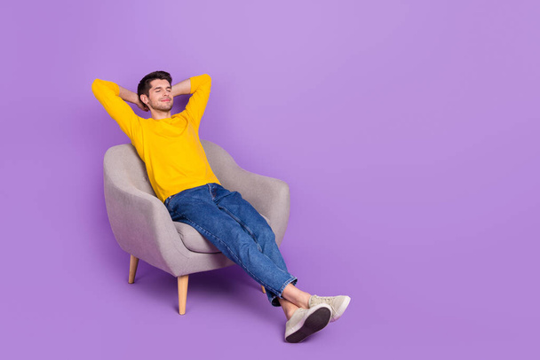 Täysikokoinen kuva hyvällä tuulella rauhallinen mies istua mukava nojatuoli on nokoset eristetty violetti väri tausta. - Valokuva, kuva