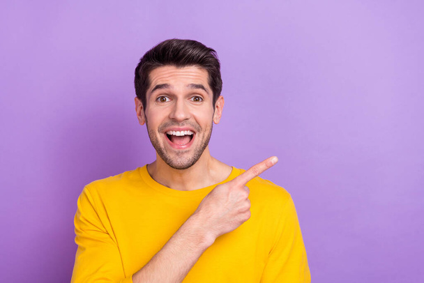 Portrait of ecstatic funny man promote recommend product huge bargains isolated on purple color background. - Foto, Bild