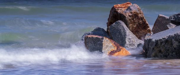 SEA COAST - Zeegolven botsen tegen rotsblokken aan de kust - Foto, afbeelding