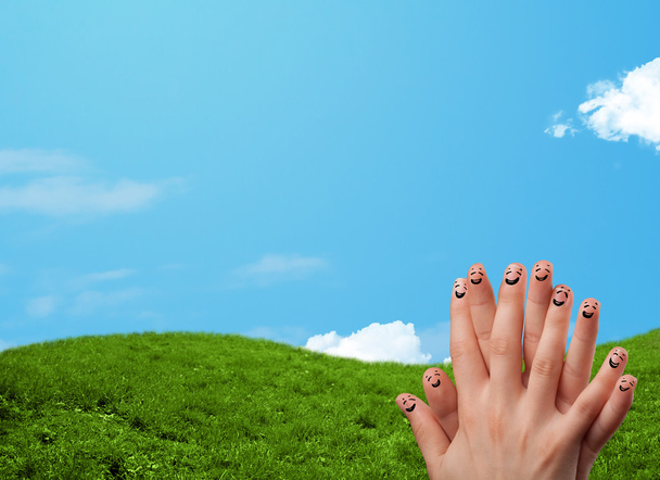 Веселые улыбки на пальцах на фоне пейзажа - Фото, изображение