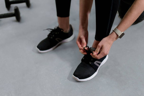 A close-up of woman Hands Tying Shoelaces On Fashion Sneakers - Фото, изображение