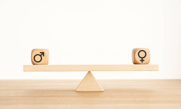 Concept d'égalité des sexes. Bloc en bois avec icône de genre sur une balançoire. Espace de copie - Photo, image
