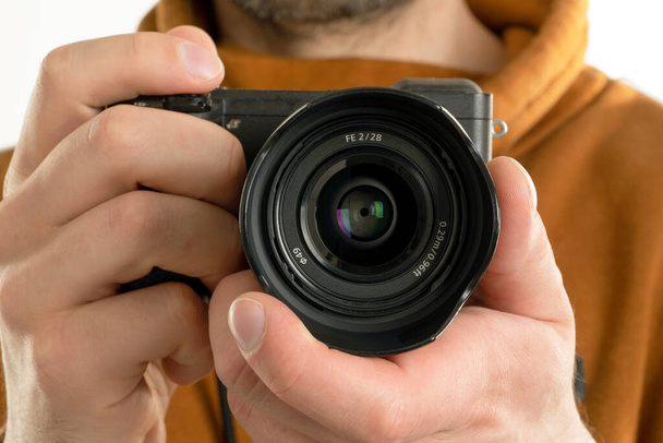 A close up image of man holding digital camera, photographer, photography studio - Фото, зображення