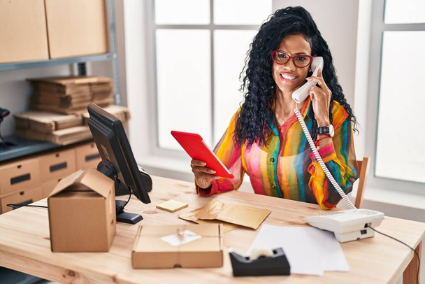 Afrikai amerikai nő e-kereskedelmi üzletember használja touchpad beszél telefonon az irodában - Fotó, kép