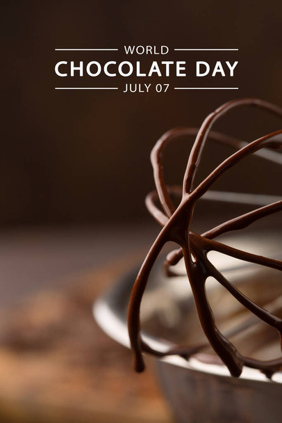 Weltschokoladentag, 7. Juli. Geschmolzene hausgemachte Schokoladencreme in Schüssel mit Schneebesen auf dunklem Holzhintergrund, selektiver Fokus. Grußkarte oder Bannerkonzept. - Foto, Bild