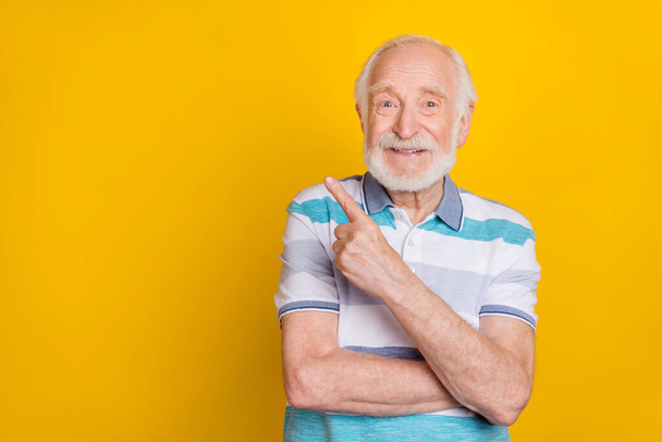 Portrait of attractive cheerful grey haired man demonstrating copy space way isolated over bright yellow color background. - Φωτογραφία, εικόνα