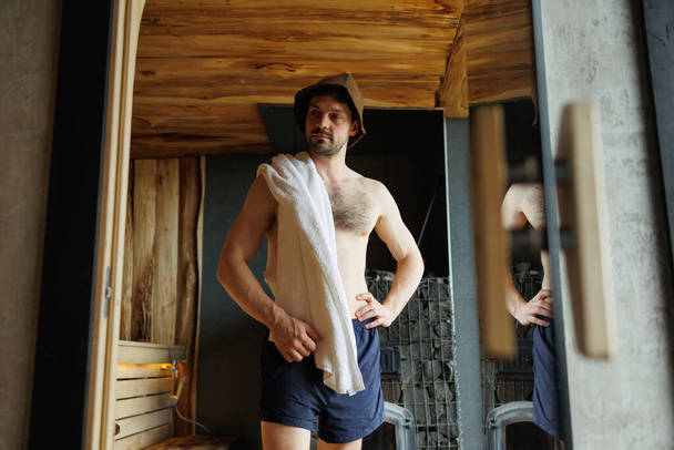 Man with a towel on his shoulder in the sauna - Foto, afbeelding