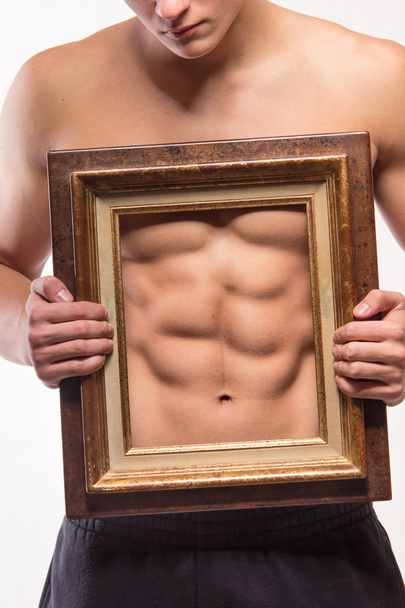 Muscular man with six-pack and frame on his torso - 写真・画像