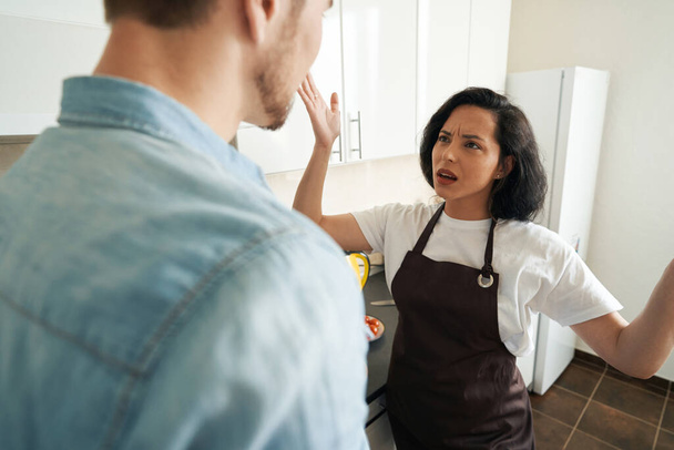 Angry woman gesticulating and shouting at male companion during their quarrel at home - Foto, afbeelding