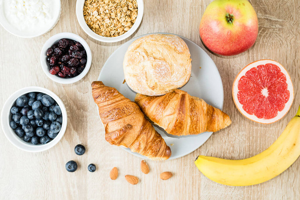Gesundes Frühstück. Croissants, Brötchen, Quark, Beeren und Früchte und Beeren. Ansicht von oben. Langes Banner-Format - Foto, Bild