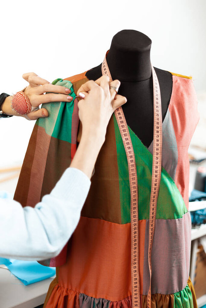 Fashion designer at work. The tailor sews a creative dress. Handmade clothes. - Foto, afbeelding